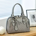 Chic gray handbag with glossy patent and crocodile texture on a stylish rattan surface - Gray