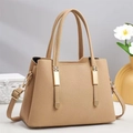 Elegant beige leather handbag with gold metal buckles and crossbody strap on marble stand - Apricot