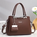 Dettaglio borsa a mano in pelle marrone scuro con manico argento e mini charm per borsa - Marrone