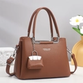 Brown leather crossbody handbag with silver metal handles and a miniature charm pendant - Khaki/Earth Yellow