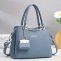 Detail der nebelblauen Ledertasche mit Narbenleder, Silberbeschlägen und Anhänger - Blau
