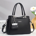 Dettaglio borsa nera in pelle martellata con finiture argento e doppi manici corti - Nero