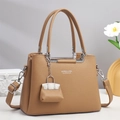 Close-up of khaki pebbled leather handbag with silver hardware and mini bag charm accessory - Khaki