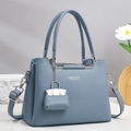 Detail of blue lychee grain leather handbag with silver hardware and tulip decor - Blue