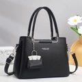 Dettaglio borsa in pelle martellata nera con finiture argentate e ciondolo coordinato - Nero