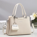 Dettaglio della borsa in pelle crema con trama intrecciata e mini ciondolo coordinato - Bianco Sporco