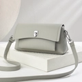 Minimalist light grey leather crossbody bag with adjustable strap on white stone base - 23cm x 8cm x 12cm / Gray