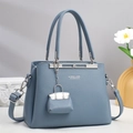 Close-up of fog blue lychee pattern leather handbag with silver hardware and small charm - Blue