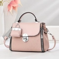 Close-up of pink crossbody bag with textured fabric, silver twist lock and charm detail - Pink