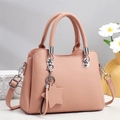 Pink pebbled leather tote bag with star charm and detachable strap on white display pedestal - Pink
