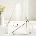 Minimalist white lychee leather crossbody bag with silver hardware and front pocket details - Off-white