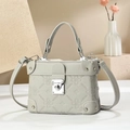 Detail of green box bag featuring four-leaf clover embossing and silver heart-shaped lock - Gray