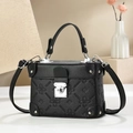 Detail of black pebbled leather box bag with floral embossing and silver metal twist lock - Black