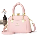 Detailed view of pink shell-shaped tote bag with gold hardware and gemstone closure - Pink