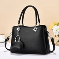 Elegante schwarze Handtasche mit Kieselmaserung, Silberbeschlägen und Mini-Anhänger - Schwarz