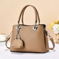 Details der hellbraunen Tasche mit Lychee-Muster, silberner Kette und Metallteilen - Kastanie