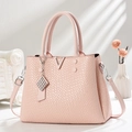 Sac fourre-tout rose gaufré croco avec détail V doré et bandoulière sur fond élégant - Rose
