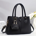 Elegant black pleated tote bag with mini charm pouch and golden hardware on white background - Black