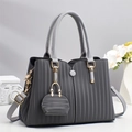 Detail view of grey pleated handbag with gold hardware and mini coin purse pendant - Gray