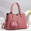Detail view of pink tote bag showing vertical striped texture and golden hardware - Pink