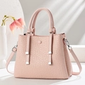 Detail of light pink woven texture crossbody bag with circular handle and thin shoulder strap - Pink