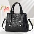 Black woven texture tote bag with silver hardware and detachable shoulder strap on white stand - Black