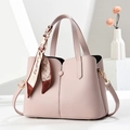 Pink lychee texture shoulder bag with decorative scarf and shoulder strap in white studio - Pink