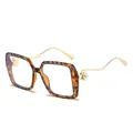 Lunettes carrées léopard avec branches dorées ondulées et détails de perles - Monture Écaille Verre Transparent