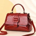 Close-up of wine red crocodile embossed patent leather handbag with glossy finish - Wine Red