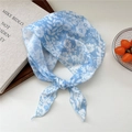 Light blue floral neckerchief tied as a triangle scarf on a rustic background - Large Blue Flower Border