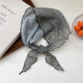 Elegant black and white houndstooth neck scarf tied in a knot for chic summer styling - Black and White Plaid