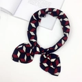 Navy and wine red geometric 3D cube print silk scarf tied in a bow over a book - Geometric Block Blue (FJ7016)