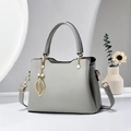 Elegante graue Handtasche mit Litschi-Textur, goldenem Blattanhänger und Riemen - Grau