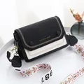 Sac bandoulière noir et blanc chic avec bandoulière brodée sur un plateau blanc - Noir