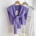 Dettaglio di scialle in maglia a trecce viola su camicia bianca e gruccia in legno - Viola