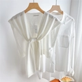 Detail of a beige knitted shawl knotted over a white cotton long-sleeved shirt - Cream