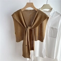 Close-up of brown knit shawl with silver sequins and lace-up knot on a white shirt - Camel