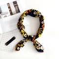 Linen square scarf with orange floral pattern and daisy print tied in a stylish loop knot - Yellow