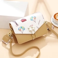 Fashionable crossbody bag with travel print and pearl cat-shaped buckle on warm background - Yellow