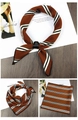 Close-up of caramel brown striped silk scarf with elegant black leather buckle detail - Striped Brown