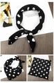 Polka dot silk scarf with leather buckle shown in folded and knotted styles on a wooden desk - Black Polka Dot