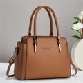 Brown lychee leather handbag with dual handles and adjustable strap on a white display stand - Earthy Yellow