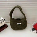 Detail of green knitted tote bag featuring a wooden olive button and minimalist logo tag - Green