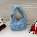 Detail of light blue knit handbag featuring a wood toggle button and soft texture - Blue