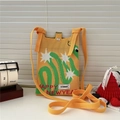 Detail of yellow knitted mini crossbody bag featuring star patterns and holiday text - Happy New Year Snake