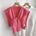 Dettaglio di scialle in maglia rosa con trama intrecciata su camicia bianca e gruccia - Rosa Pesca