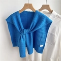 Dettaglio dello scialle in maglia a trecce blu scuro sopra una camicia bianca - Blu Zaffiro
