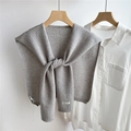 Detail van grijze gebreide sjaal met HELLO ACHY label op wit shirt en houten kledinghanger - Lichtgrijs