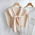 Gedetailleerde gebreide textuur van crème gehaakte sjaal met merklabel aan hanger - Beige Abrikoos