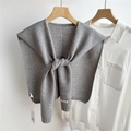 Close-up of gray hollowed knit shawl cape with brand label on white shirt - Medium Grey